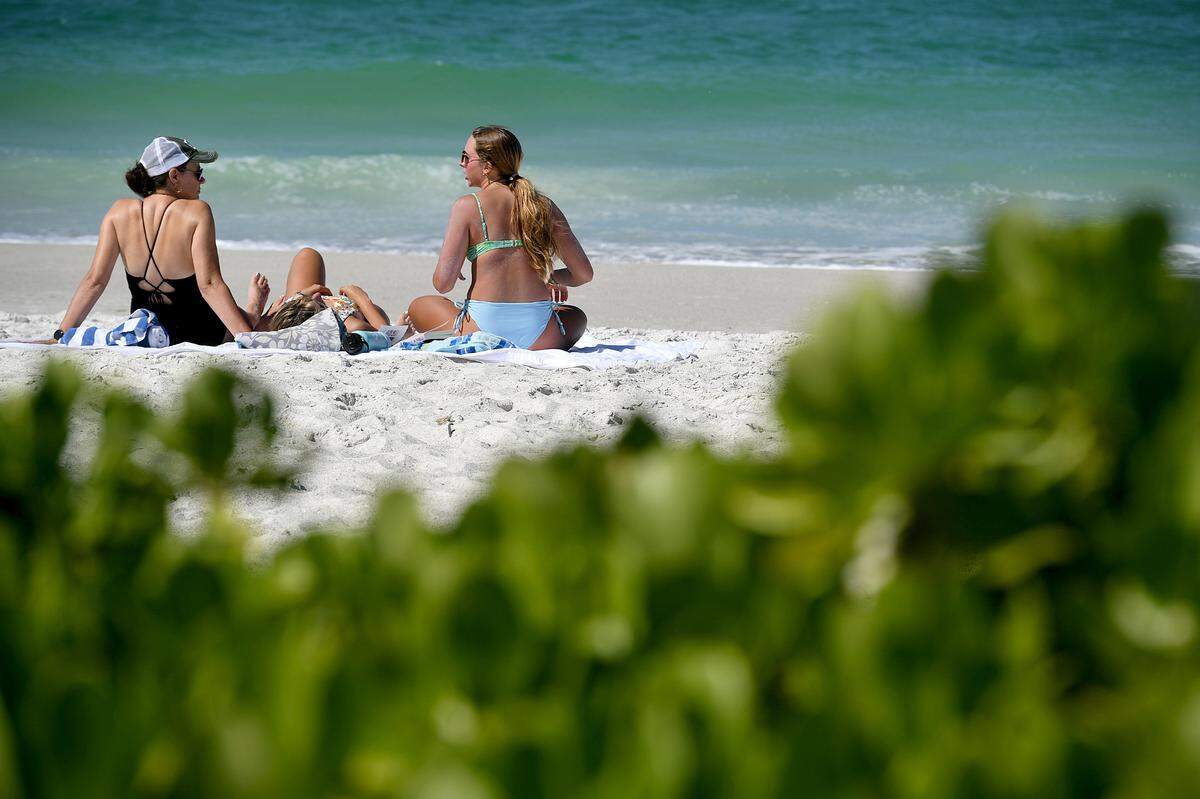 Young people enjoy the beach and weather just feet away from a roundtable discussion on increased levels of red tide in the Southwest Florida at the Beach House Restaurant in Bradenton Beach Friday.