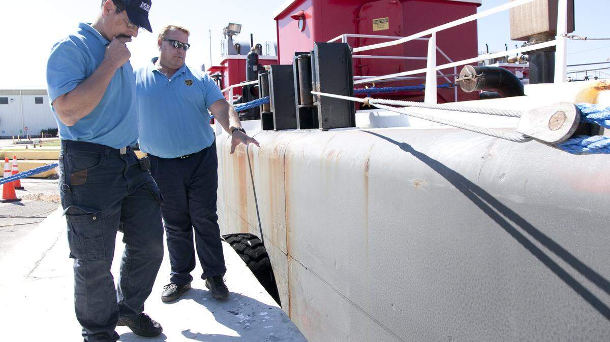 Port Manatee security officers David St. John and Lt. Buck Martin inspect a barge berthed to take on cargo at the port. A proposed port security plan would have Port Manatee running all security operations on its property. MATT M. JOHNSON/Bradenton Herald