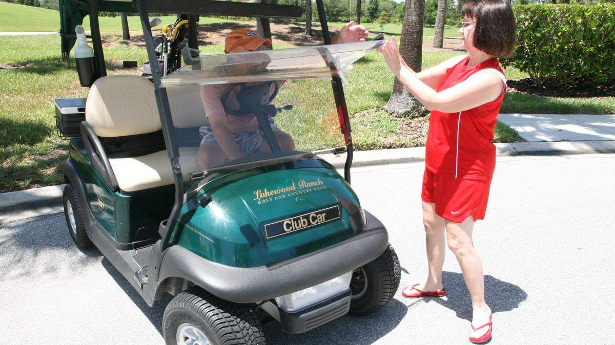 File Photo by RICHARD DYMOND/rdymond@bradenton.com 
 Glenda Robertson, right, shows how golf carts must have a windshield, along with other equipment, in order to be legal to drive at all times on the road.