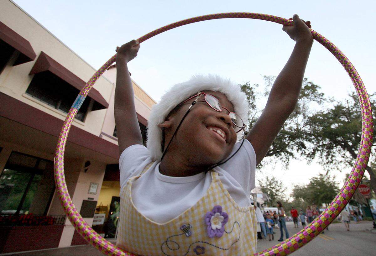 Jalynne Brown, 7, takes a break from being a Munchkin in Manatee Player’s Wizard of Oz to stroll with her mom through downtown Bradenton’s Winter Wonderland.