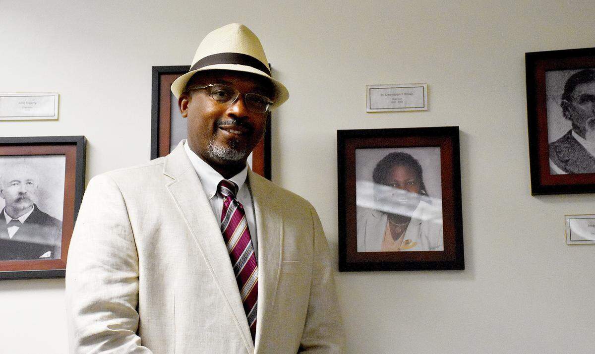 Commissioner Reggie Bellamy poses next to a photo of Gwendolyn Brown (right), Manatee County’s first Black commissioner. Bellamy, 50, was recently nominated to join the Florida Council on the Social Status of Black Men and Boys, which aims to reduce socioeconomic disparities among Black residents.