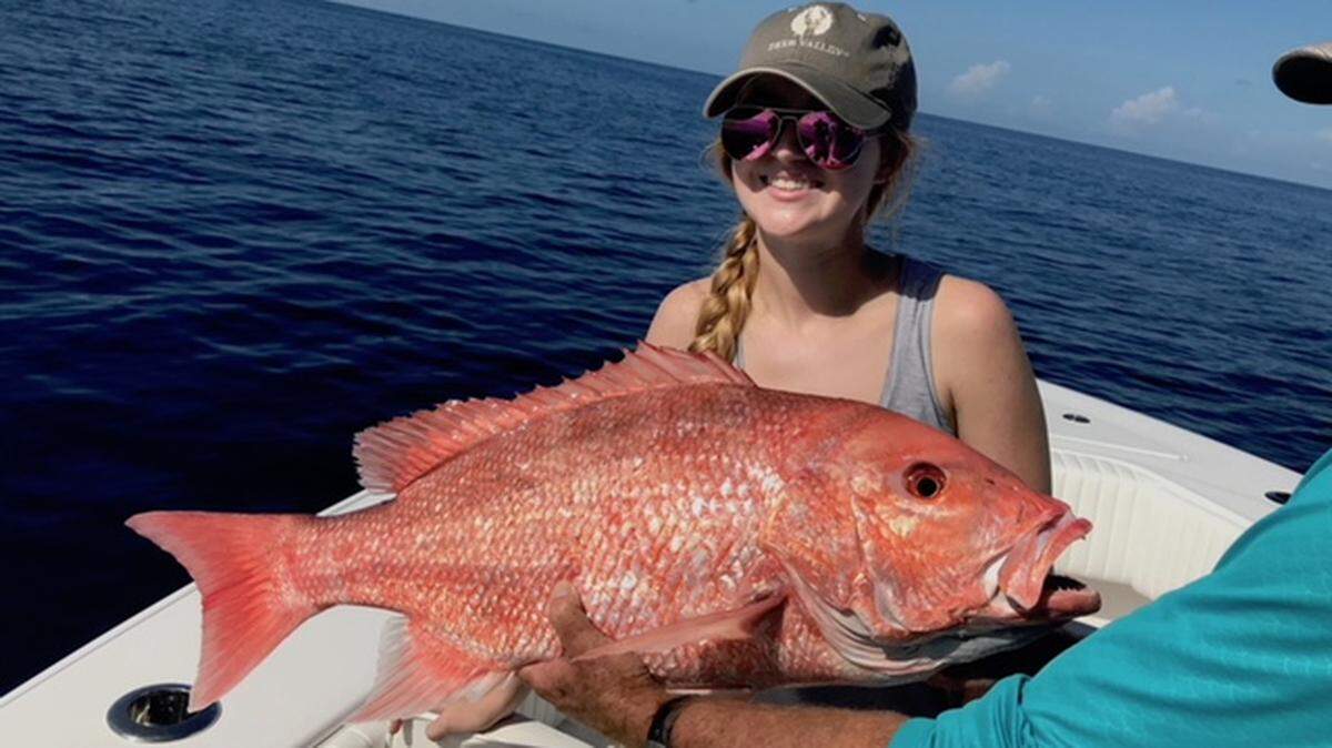 Eva Preston poses for a photo with a 15-pound red snapper she caught about 60 miles offshore.