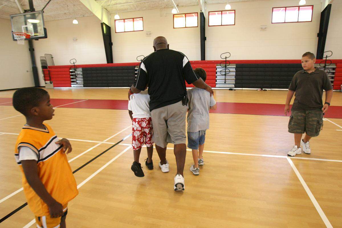 Palmetto Boys and Girls Club director Willie Cooper quietly quells a disagreement between two youngsters in the gymnasium at the new Palmetto Club in 2010.