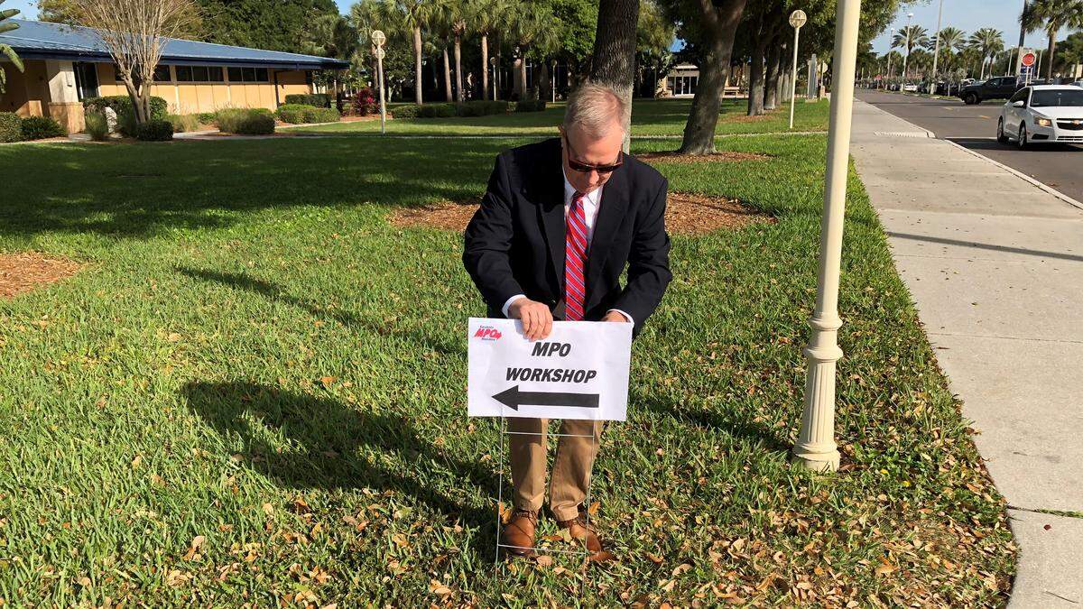 Dave Hutchinson, executive director of the Sarasota/Manatee Metropolitan Planning Organization, puts down a sign directing participants to the location of the Transform Tomorrow forum Monday at State College of Florida. The community vision for traffic flow in Manatee and Sarasota counties over the next 50 years was presented