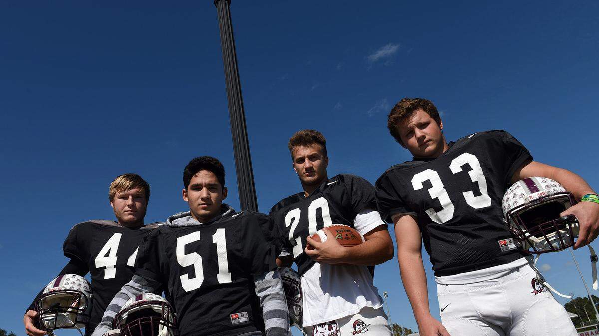 Braden River linebackers Matthew Haftke, Noah Arce, Taylor Pawelkoski and Ronnie McClellan stand together under a lamp post near their practice field. 
 TIFFANY TOMPKINS-CONDIE/Bradenton Herald