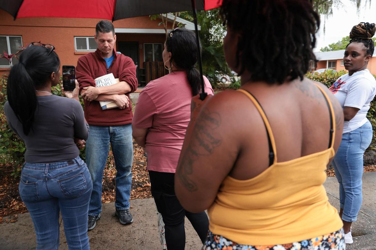 Surrounded by current and former tenants, Jason Kraft, a resident commissioner of the Housing Authority Board, avoids the questions launched by the group of women tenants.