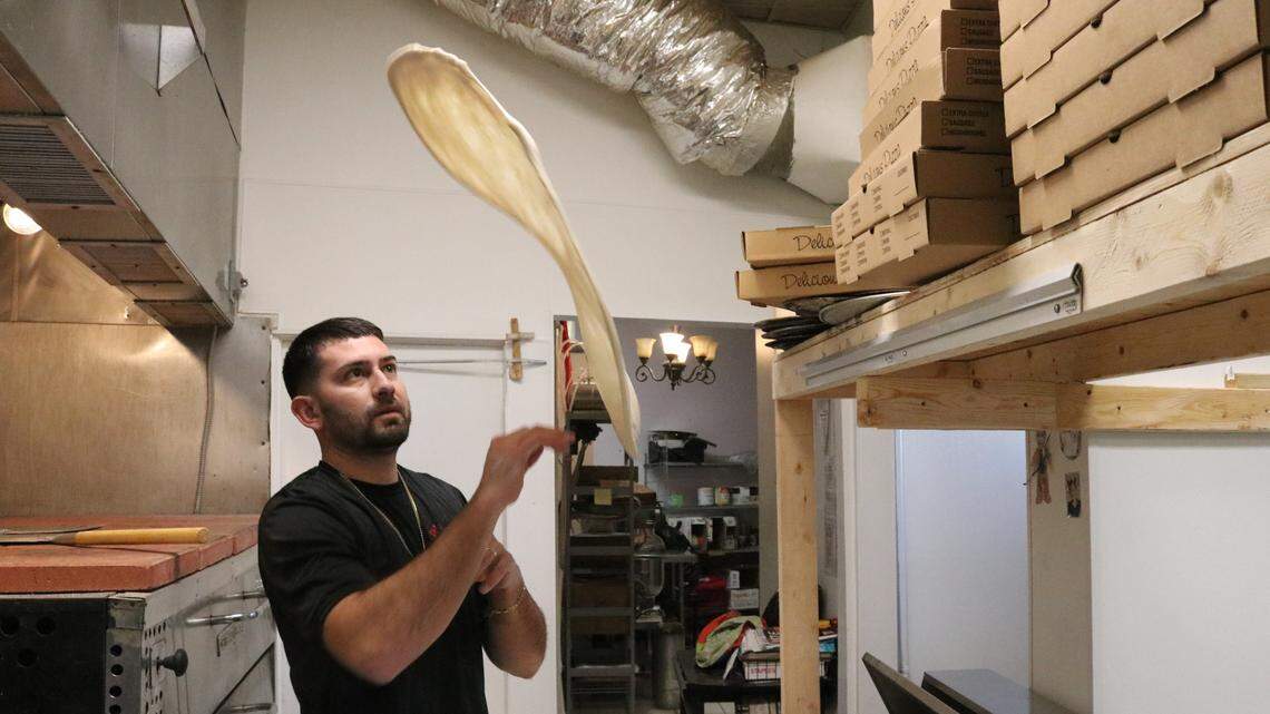 Enrique Gonzalez tosses a wheel of dough that will become a cheese pizza at Nonna’s Pizza Restaurant, 7604 Cortez Road, Bradenton.