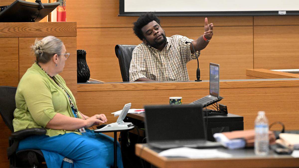 Joseph Brice demonstrates a gesture made in the a nightclub called The Hall between two groups of people on the night Jerome Miller was shot in 2019, while testifying at the Manatee County Judicial Center on Tuesday, April 9, 2024.