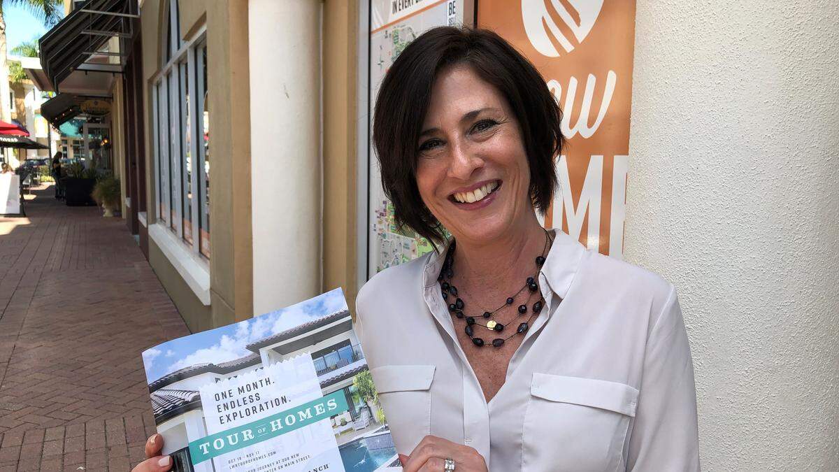 Jacqui McGovern, community specialist at Lakewood Ranch, holds a copy of the Tour of Homes program. The tour is a month long, starting Oct. 18 and ending Nov. 17.