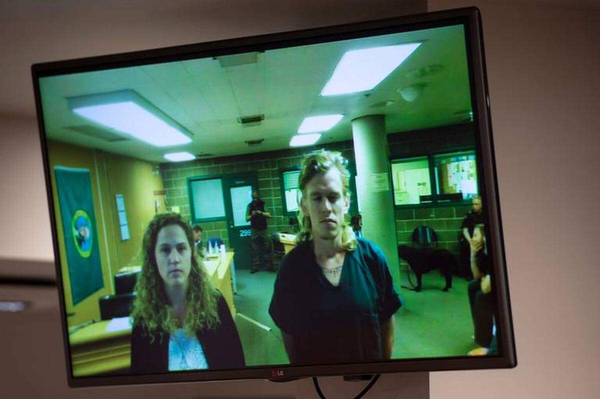 Ryan Nolan MacFarlane, right, stands beside Whatcom County Public Defense attorney Mamie Lackie during his first appearance in Whatcom County Superior Court in Bellingham on Monday. MacFarlane was accused of making a bomb threat Sunday at the Regal Cinemas movie theater