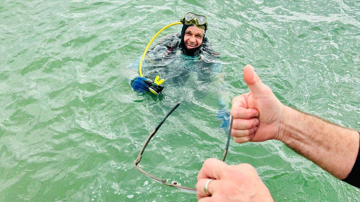 Manatee County tour guide Troy Brown poses in the water after recovering a pair of $1,000 prescription glasses that fell into 15 feet of water off Bradenton Beach.