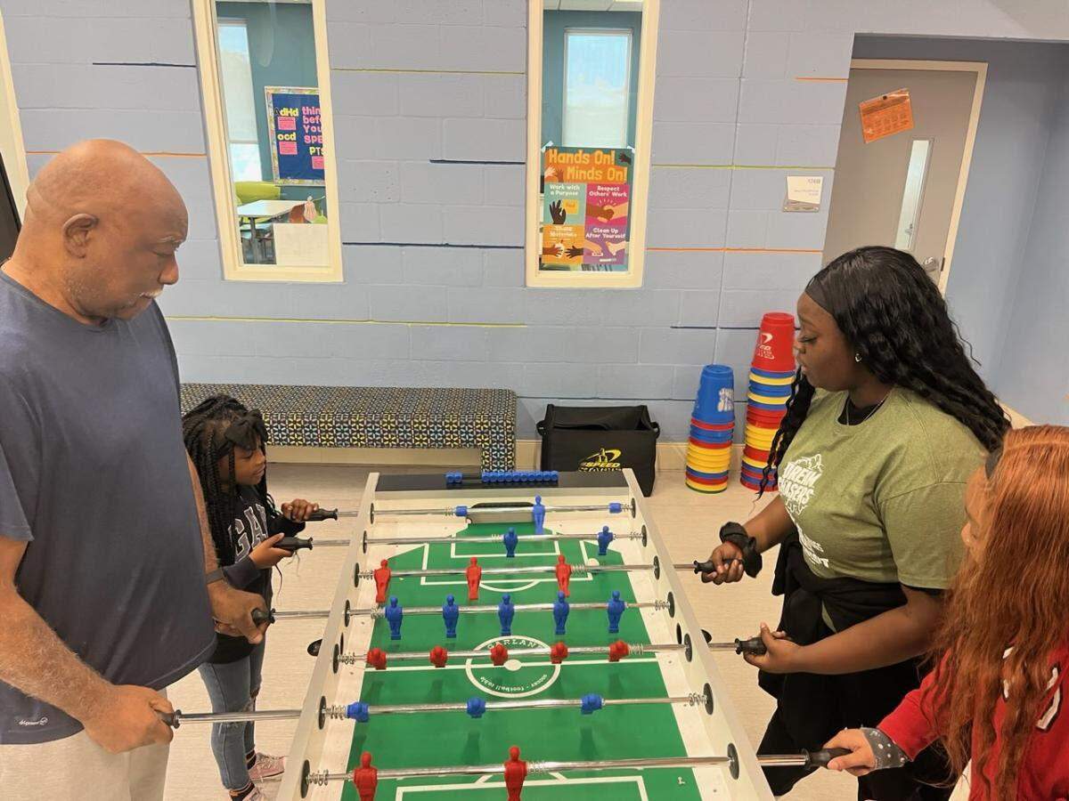 Willie Cooper (left) and Club member Trinity D (left) play foosball at the Desoto Boys & Girls Club. Cooper retired from the Boys and Girls Club in February after 40 years.