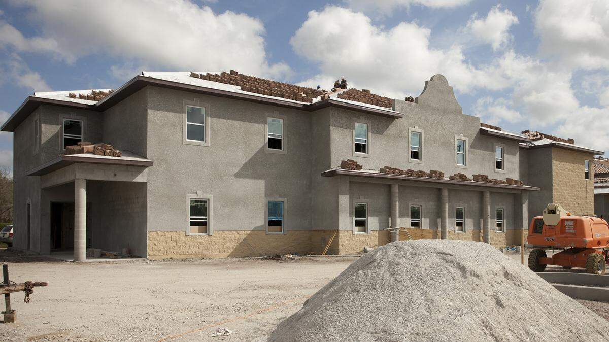 Roofers pause during their work day as construction work continues at the future Harmony Palms assisted living facility. The project's developer had initially predicted a late-2015 finish date for the project after breaking ground the previous February. MATT M. JOHNSON/Bradenton Herald