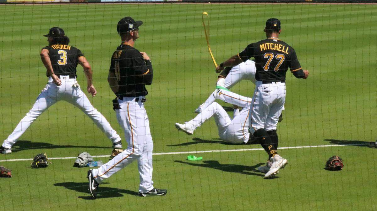 Members of the Pittsburgh Pirates baseball team limber up before hosting the New York Yankees in a Spring Training game at LECOM Park on March 18, 2022, before a crowd of about 3,000.