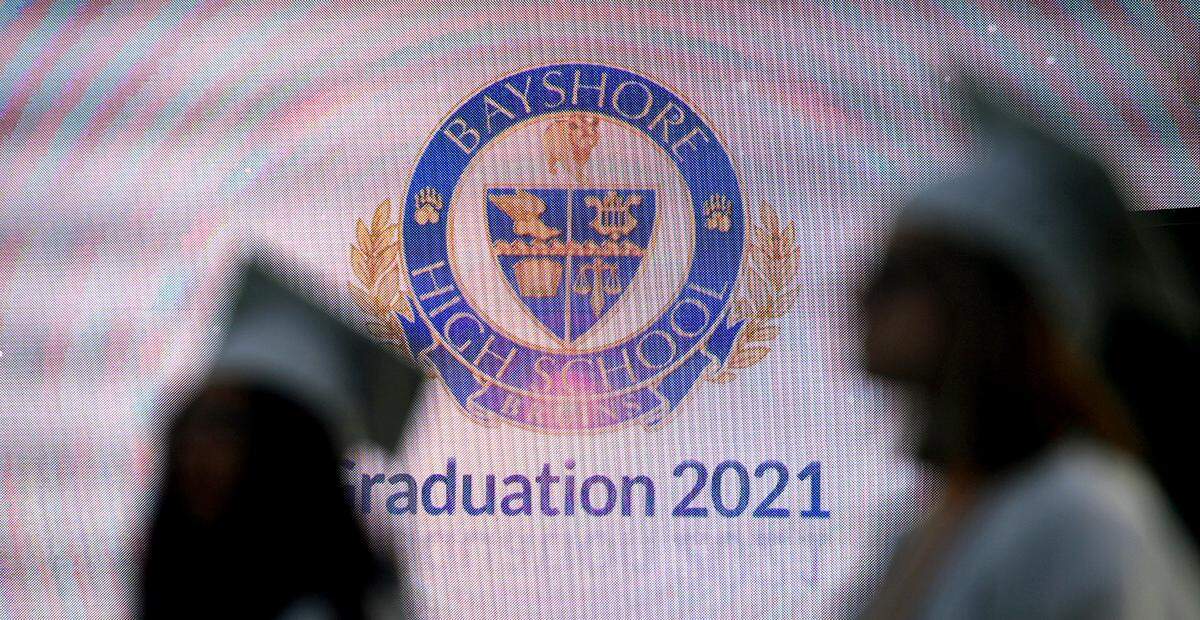 06/03/21—Graduates are outlined against the school logo on the big screen at Bayshore High School’s commencement ceremony at LECOM Field.
