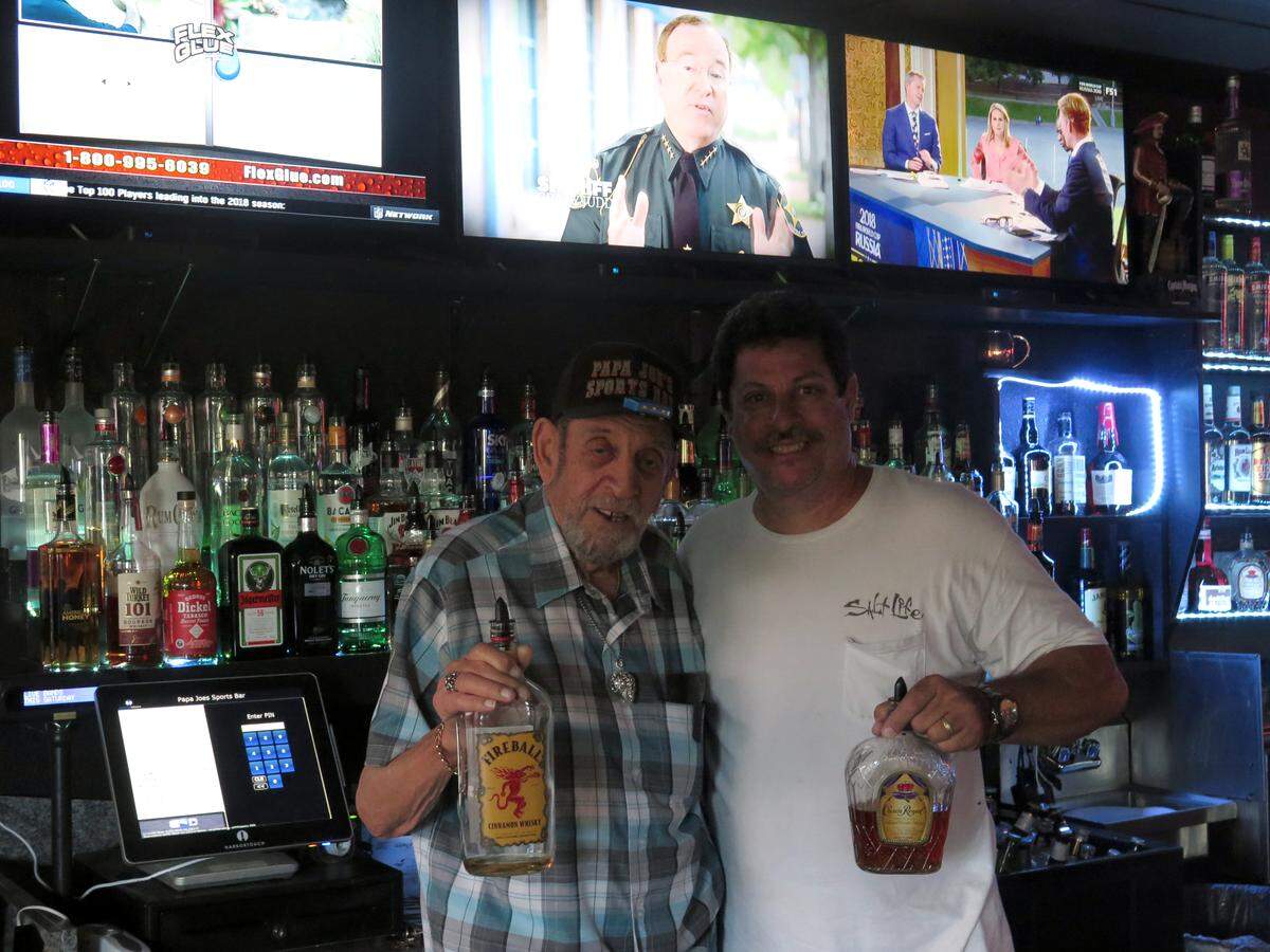 Father and son Sid (left) and Joe Harris pose for a photo behind the bar at Papa Joe's Sports Bar, 1242 Whitfield Ave. It was always Sid's dream to open a sports bar with his son, he said.