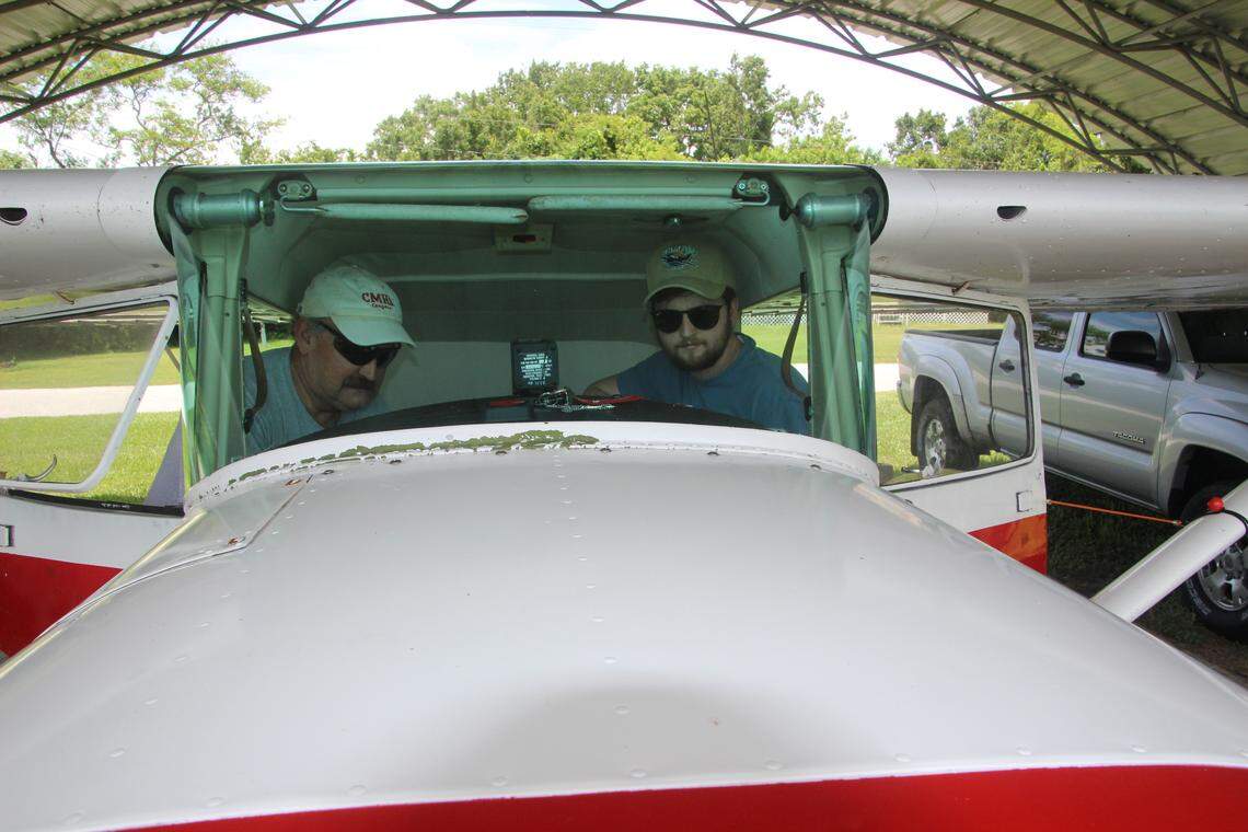 Gerry MacKinnon, left, and his son, Alec, check out the cockpit for a 1963 Cessna 150, before taking off from Airport Manatee.