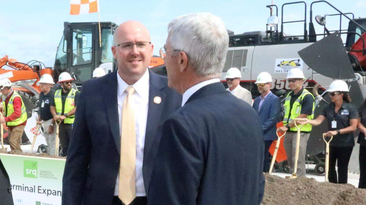 Jared W. Perdue, left, secretary of the Florida Department of Transportation, talks to Rick Piccolo, president and CEO of Sarasota Bradenton International Airport, at the groundbreaking Monday for a ground level passenger terminal.