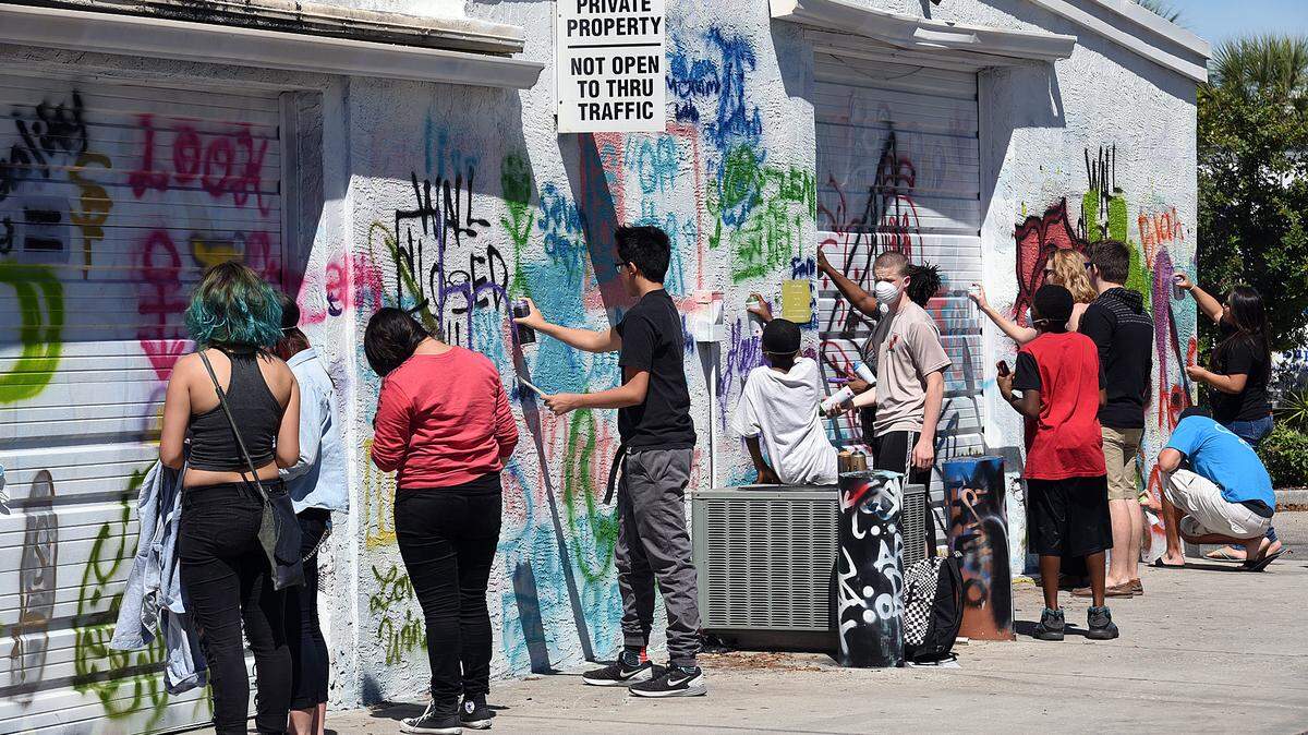 Artists work on a section of wall during the Can Jam, a graffiti art battle at Keeton's Office and Art Supply in Bradenton Saturday. 
 TIFFANY TOMPKINS/Bradenton Herald