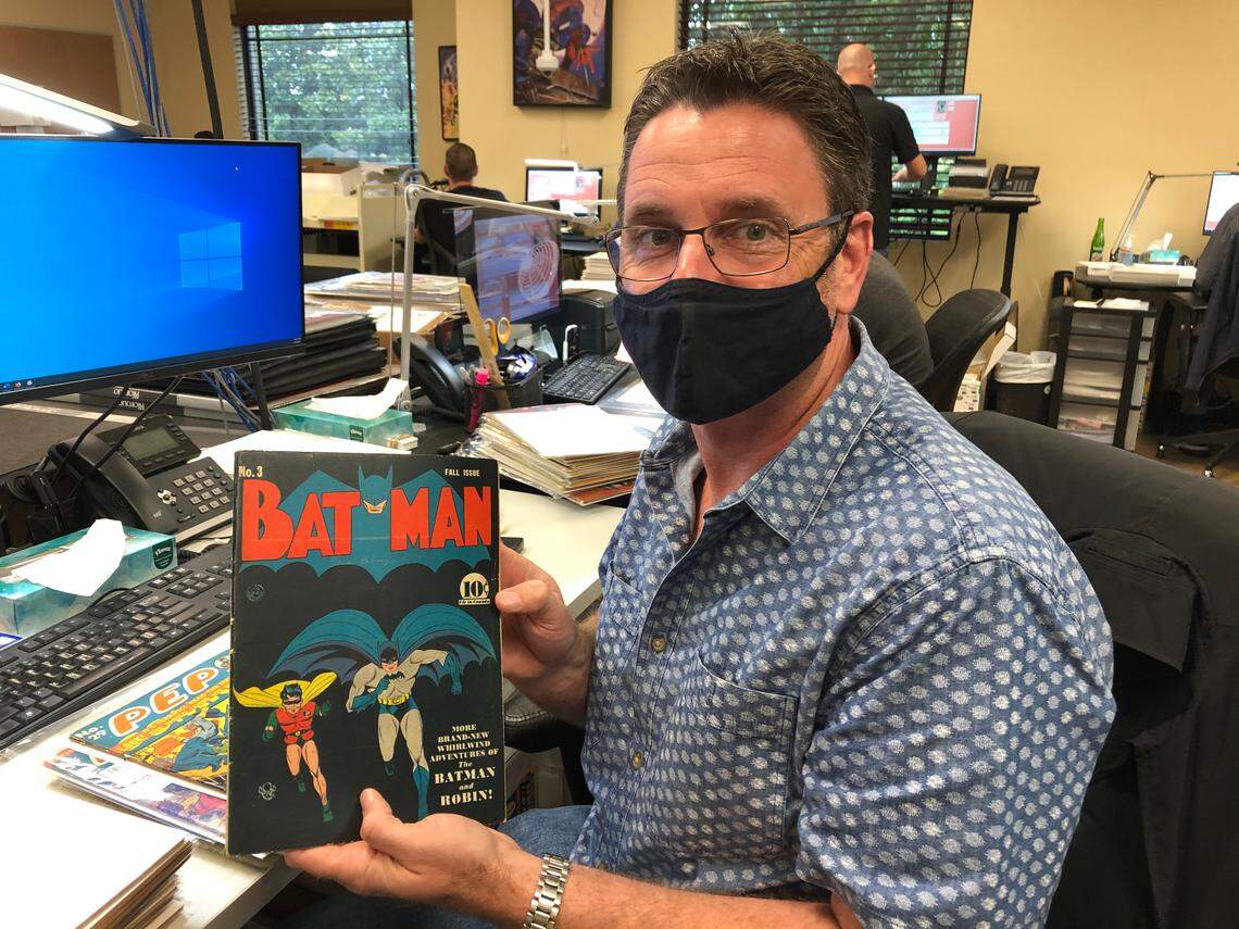 6/3/2021--Primary grader Matt Nelson of Certified Collectibles Group holds up a 1940 Batman comic. The company plans to add 100 employees by the end of summer, bringing its Lakewood Ranch workforce to 500. &nbsp;To hit this target, CCG is offering a $2,500 sign-on bonus for new employees who start by Sept. 30. 
