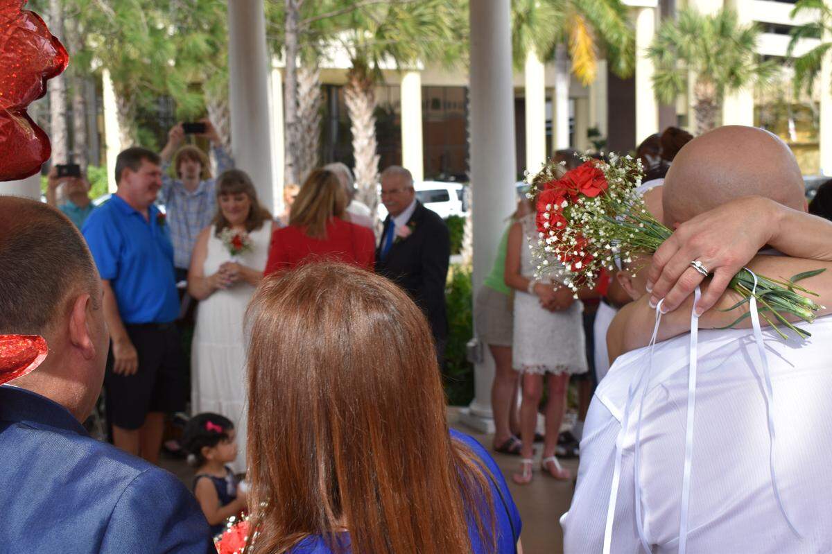 Couples embrace during the Valentine’s Day group wedding ceremony hosted by the Manatee County Clerk of Court in the gazebo on the courthouse front lawn Feb.14, 2020.