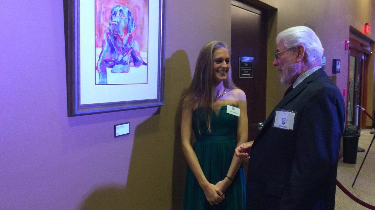 Morgan Mullholland, a Southeast High School junior, laughs Saturday with Gary Stern next to her watercolor painting, Kona, during the cocktail reception at the ninth annual Art and Soul Gala and Live Art Auction.JESSICA DE LEON/Bradenton Herald