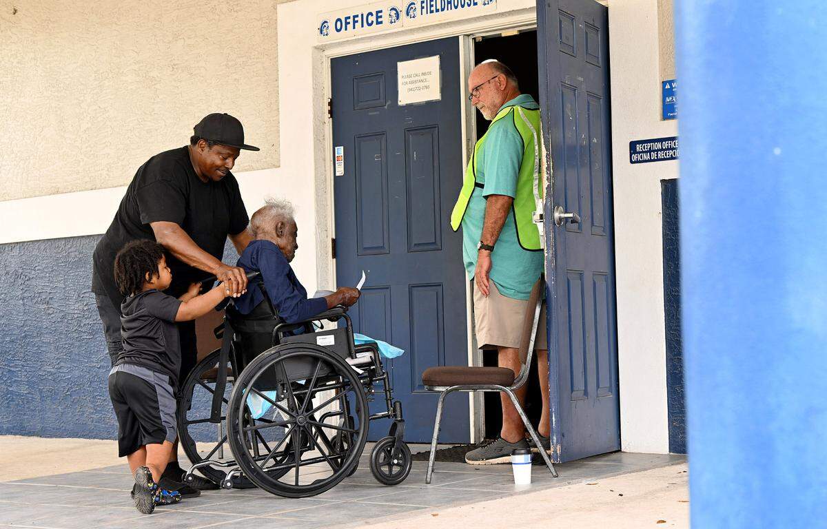 Glover Isom and his 2-year-old son, Stephon, help Ophella Isom inside to vote at the Palmetto Youth Center on Nov. 5, 2024.