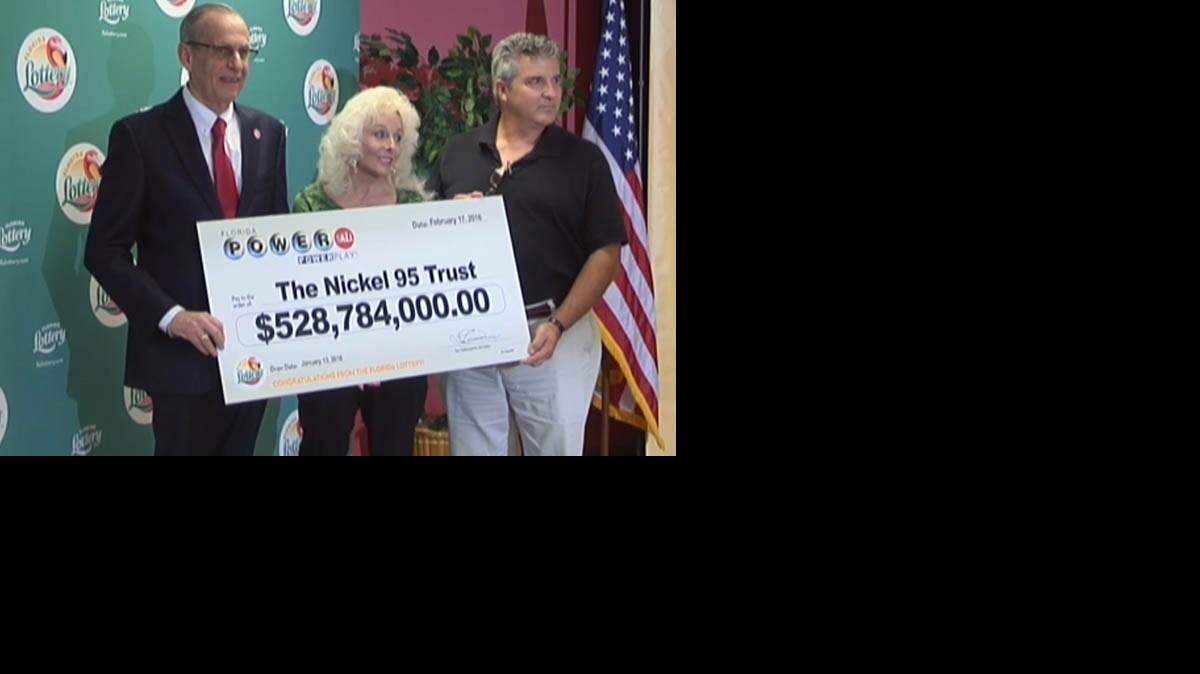 Florida Lottery Secretary Tom Delacenserie, left, with David Kaltschmidt and Maureen Smith from Melbourne Beach, Wednesday, Feb. 17, 2016.