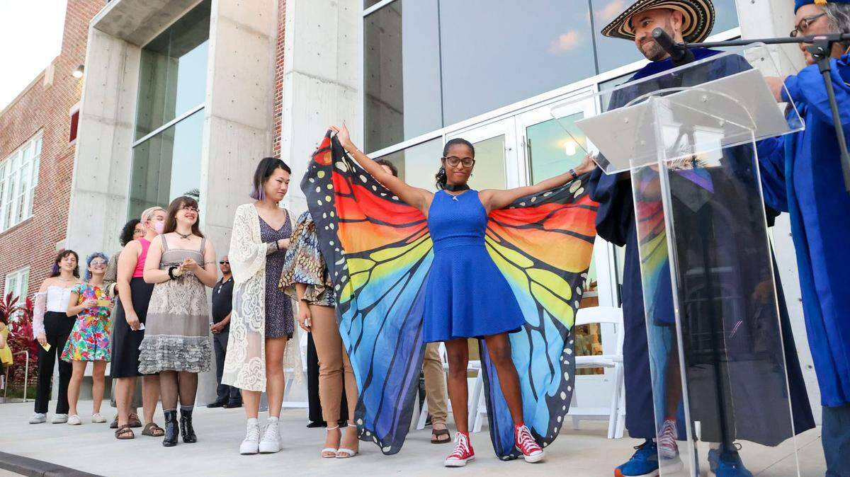 New College of Florida graduating student Grace Sherman spreads her wings while being announced during a procession of students during the college’s “alternative commencement” on Thursday, May 18, 2023, in Sarasota.