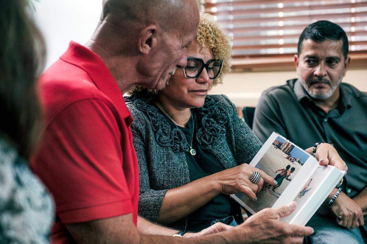 The parents of Derbin Huertas Jr., Ana and Derbin Sr., share family photos with cornea recipient Art Durshimer at Lions World Vision Institute in Ybor City.