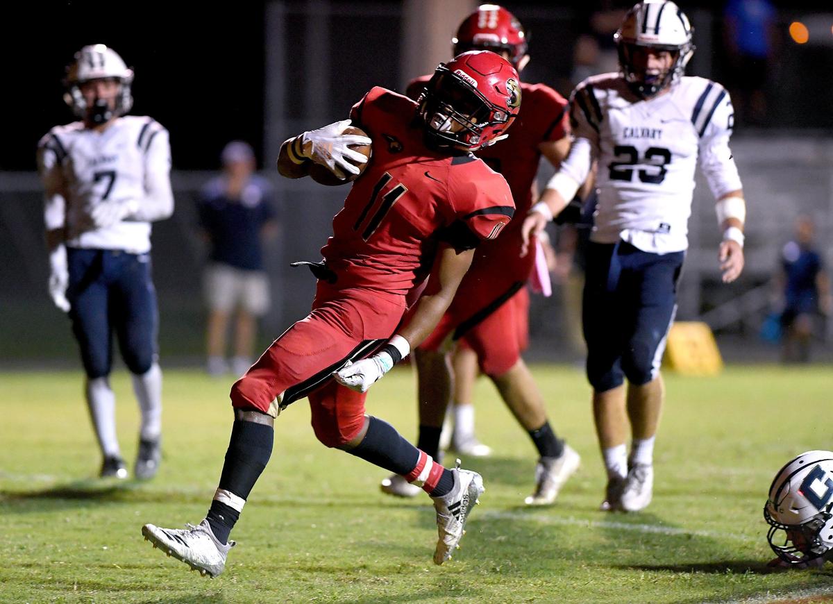 Tray Hall runs the ball during Friday night’s football game between Cardinal Mooney and Calvary Christian at Cardinal Mooney.