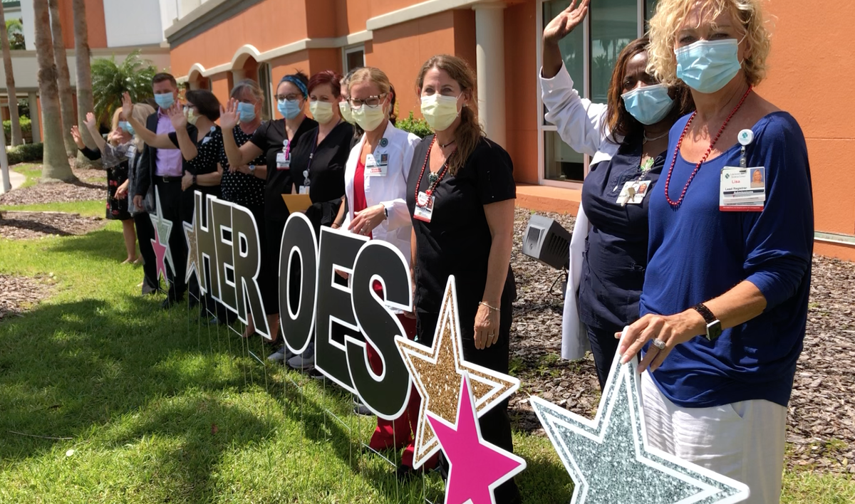 Health care workers stand outside Lakewood Ranch Medical Center to watch a parade in their honor for serving on the front line of the fight against COVID-19.