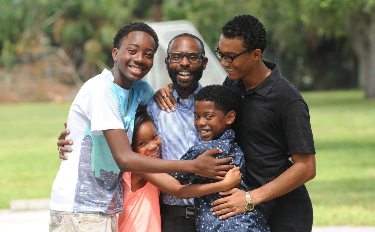 Derrick Randall, center, is hugged by his children, Robert, 16, Kennedi, 8, Darien, 11, and Tajei, 17, in their hometown of Rubonia in 2005.