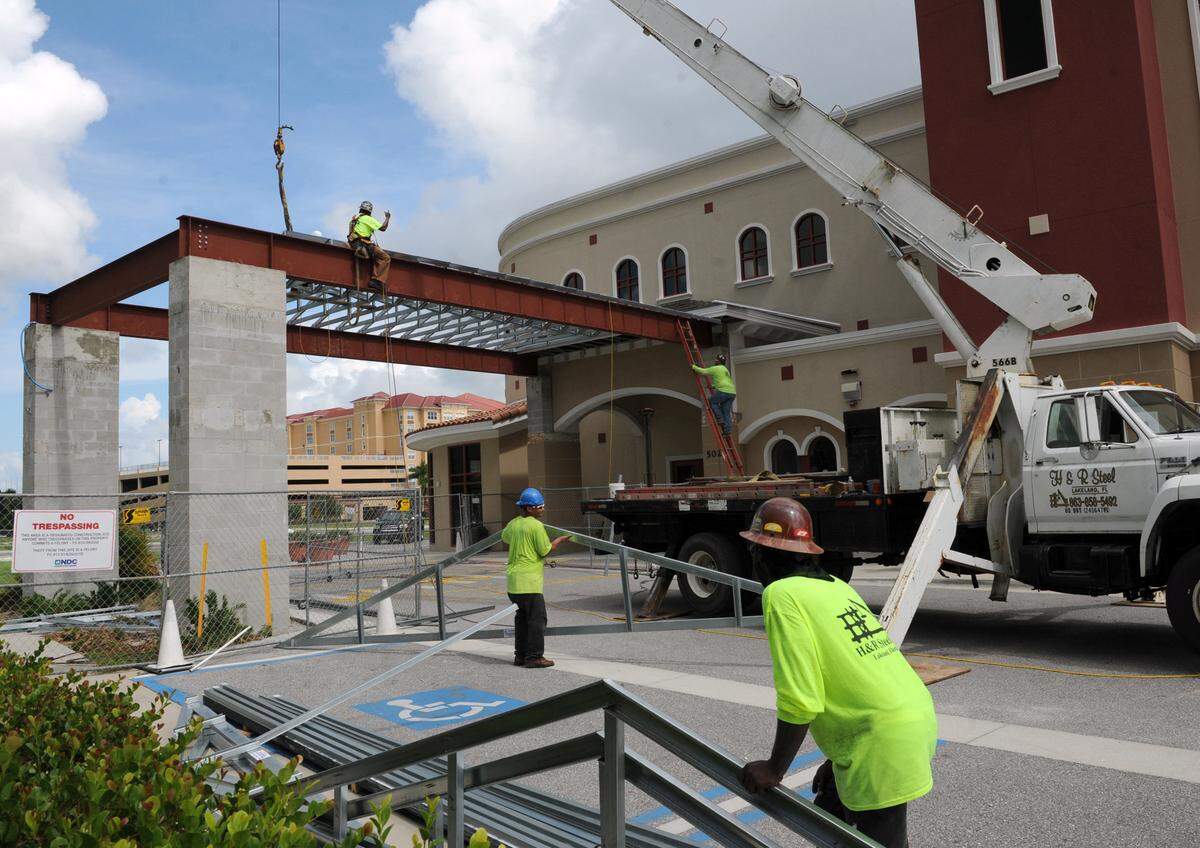 Workers with H & R Steel Inc., Lakeland, put trusses in place as they construct a new covered drop-off area at the main entrance to the Manatee Performing Arts Center in Bradenton. The cover and the installation of new automatic doors will be completed by Aug. 11, in time for the season opening production of the musical CATS, according to Janene Amick, executive director. GRANT JEFFERIES/Bradenton Herald