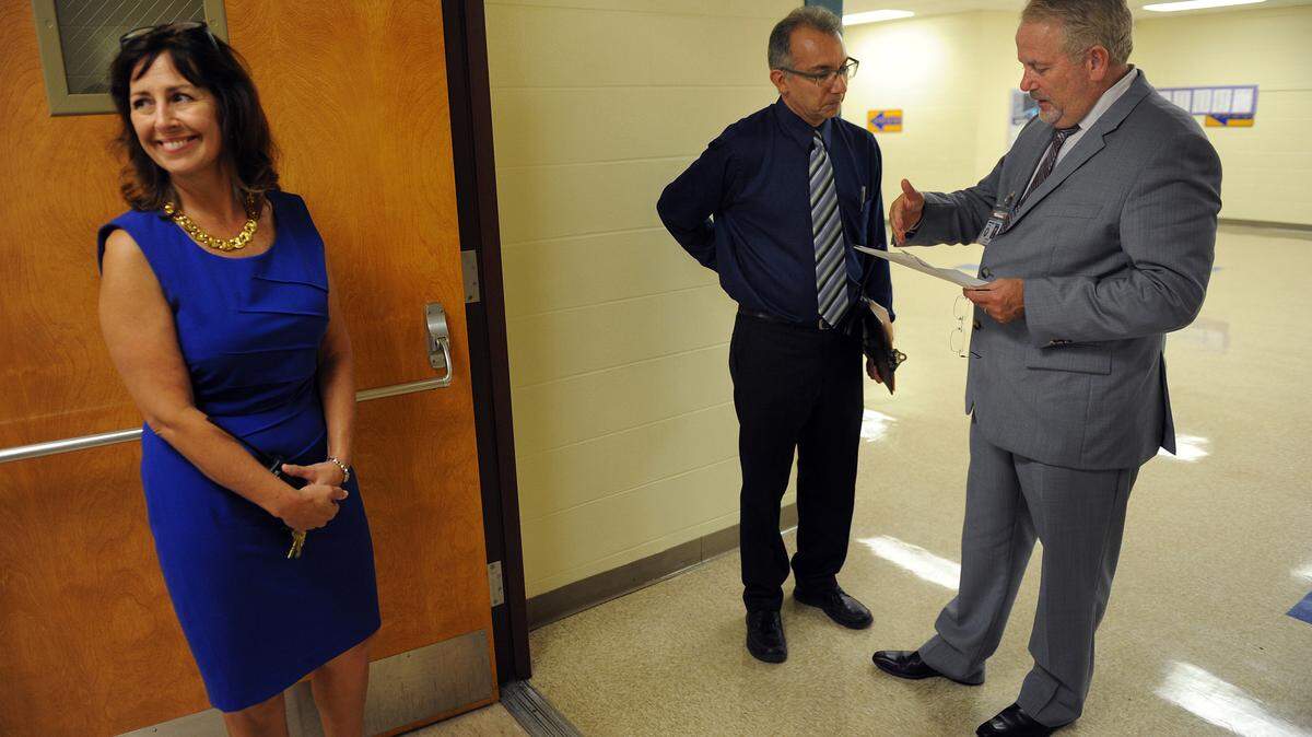 Sugg Middle School principal Darlene Proue smiles as she waits for Manatee District Superintendent Rick Mills, right, as he talks with assistant principal Brad Baietto, during a tour of the school in Aug. 2014. Proue will be reassigned to another position within the school district, according to officials. 
 File Photo-GRANT JEFFERIES/Bradenton Herald