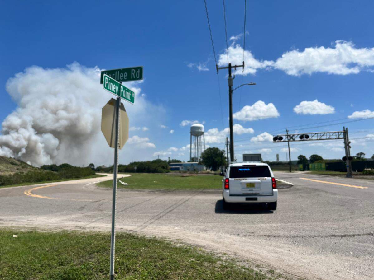 Manatee County sheriff’s deputy blocks Harlee Road to stop drivers from getting close to the fire site on Saturday, April 9, 2022.