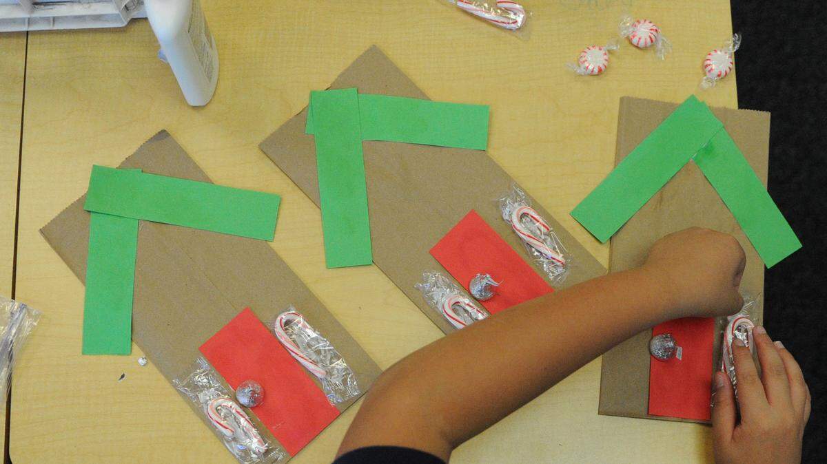 Gary Wang makes gift bags for his business, Gift Bag Bakery, on Monday at Mills Elementary School. Third-grade students will sell their products during an annual economics project at the school. 
 GRANT JEFFERIES/Bradenton Herald