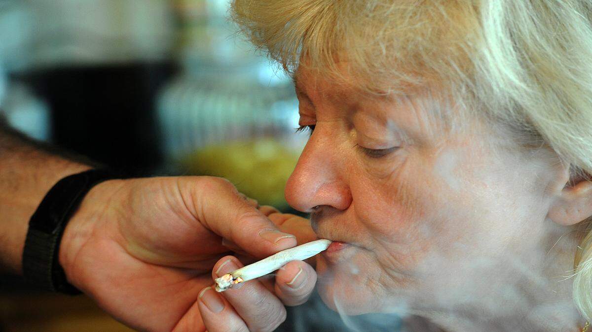 Cathy Jordan inhales deeply as her husband, Robert, holds a marijuana cigarette for her. Cathy suffers from amyotrophic lateral sclerosis, or ALS, known as Lou Gehrig’s disease. The Parrish couple say Cathy’s symptoms are greatly reduced by smoking pot.
File photo/TIFFANY TOMPKINS