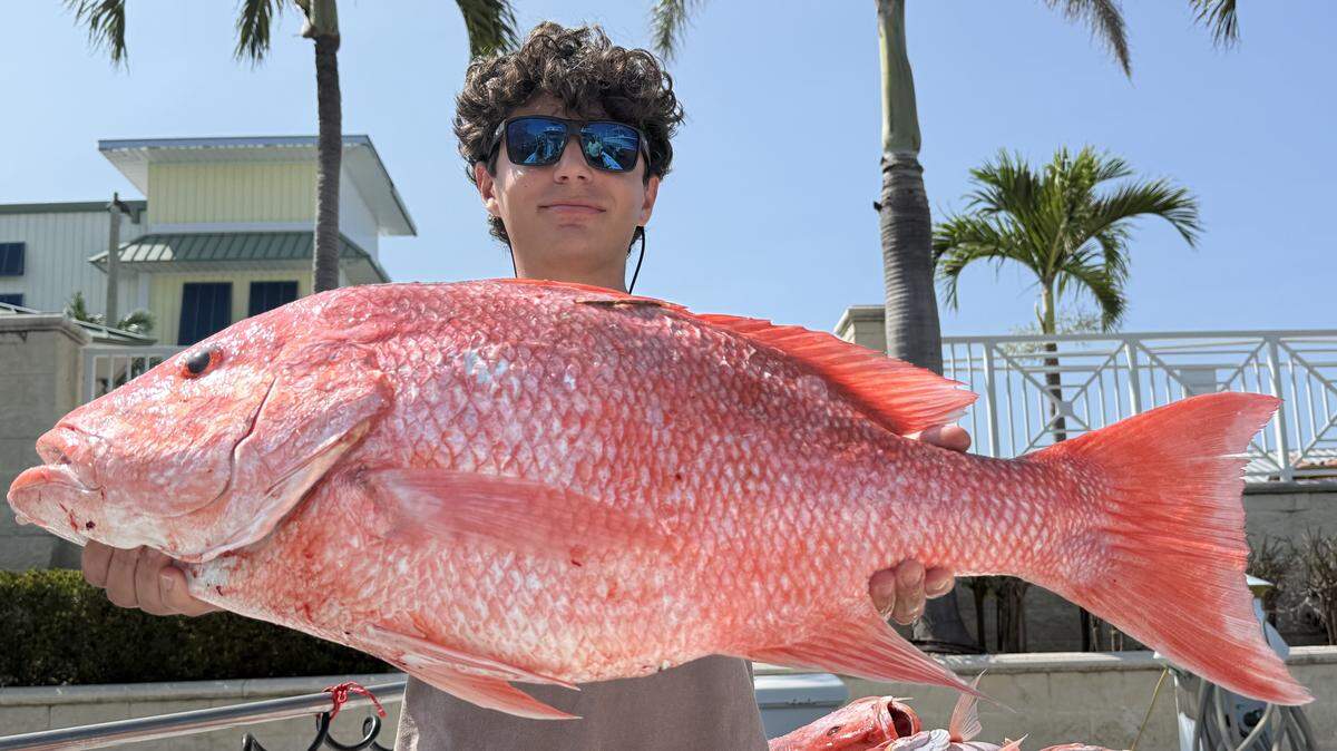 Angler Tony Figlozzi poses with a tagged 34-inch red snapper caught fishing with Captain Brian Lambert.