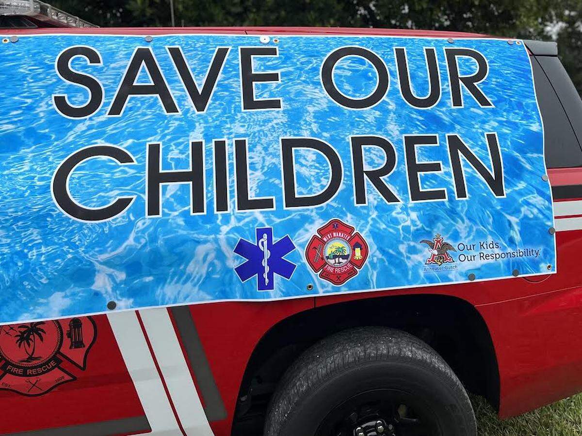 Save our children banner displayed on the side of a West Manatee Fire Rescue vehicle at the “Speaking up about a silent killer spring break 2022 Drowning prevention” press conference at Kingfish Boat Ramp in Holmes Beach,fl 03/10/2022
