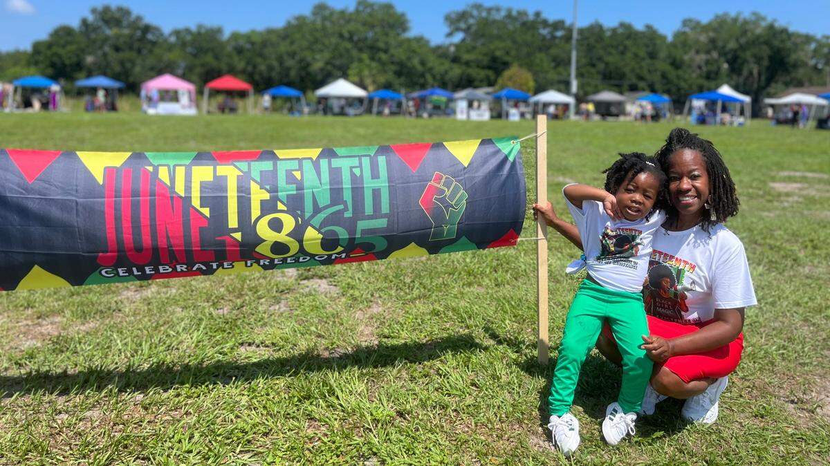 Maureen Simmons and her granddaughter, Jalia Copper stood beside a Juneteenth banner at the 13th Avenue Dream Center on Saturday.