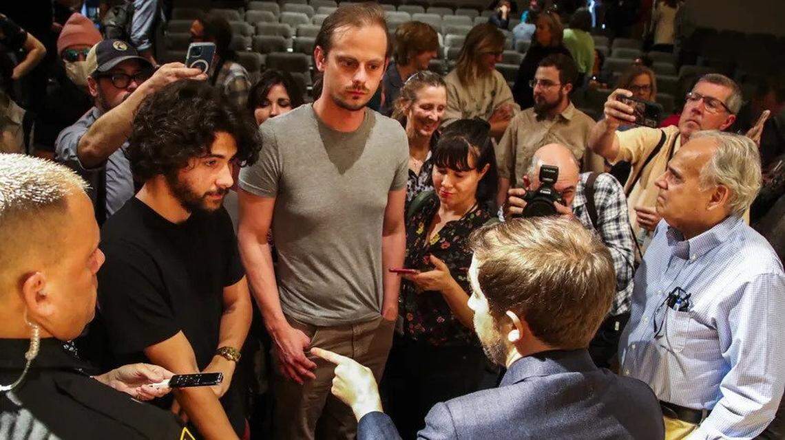 Christopher Rufo, one of six controversial new trustees at New College of Florida, talks with students at the foot of the stage after addressing an audience on the Sarasota campus Wednesday, Jan. 25, 2023.