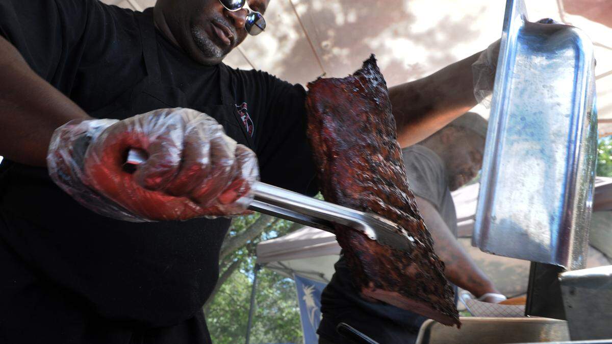 Jerome Glover, with J&J Barbecue, prepares a slab of ribs during the 29th annual Taste of Manatee event Saturday at Sutton Park in Palmetto. 
 GRANT JEFFERIES/Bradenton Herald