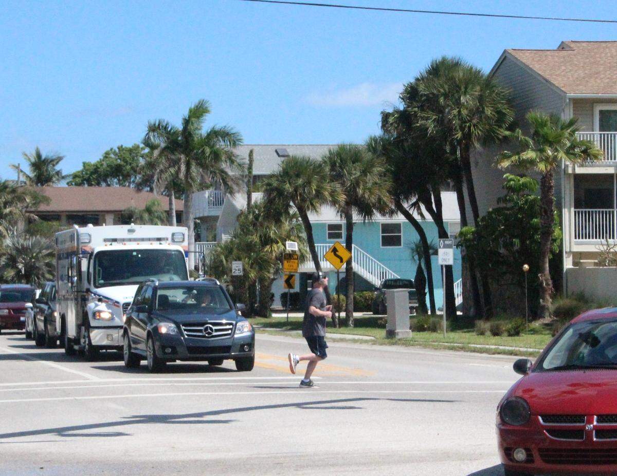 A jogger makes his way across Gulf Drive as traffic waits on Anna Maria Island on Monday.