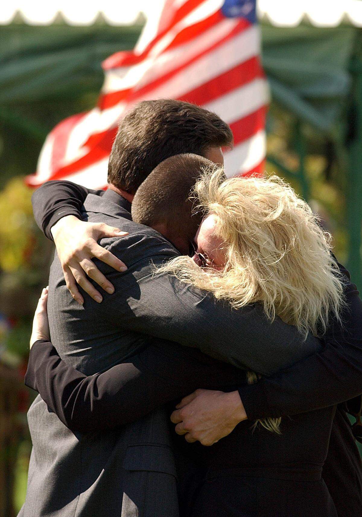 Frank Slanovits, cousin of Staff Sgt. Fred Miller who was killed in Iraq last week, hugs his son Joshua and girlfriend Alexis Berrier at the Brigadier General William C. Doyle Veteran’s Memorial Cemetery in Wrightstown, New Jersey, on Sept. 29, 2003.