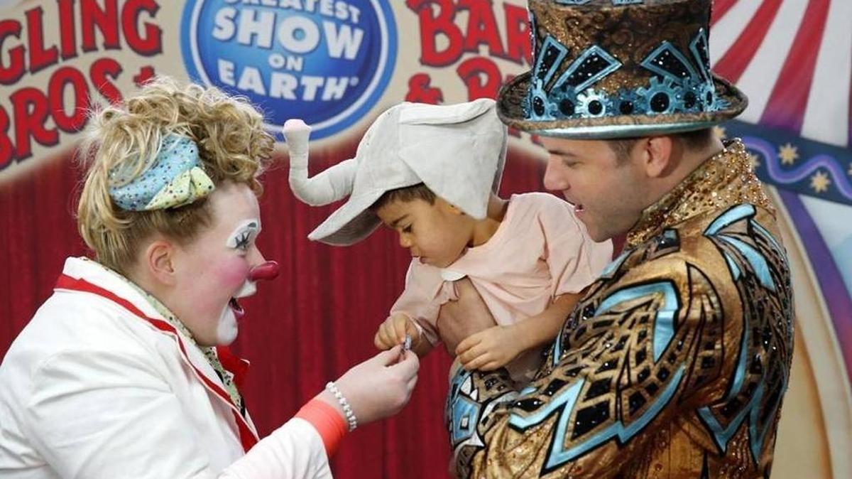 Hospital patient Dylan Aguirre, 2, with clown Lindsey Merryfield, left, and ring master David Shipman as Ringling Bro's clowns, dancers, contortionists and dogs perform at Nicklaus Children’s Hospital on Tuesday, Jan. 12, 2016.