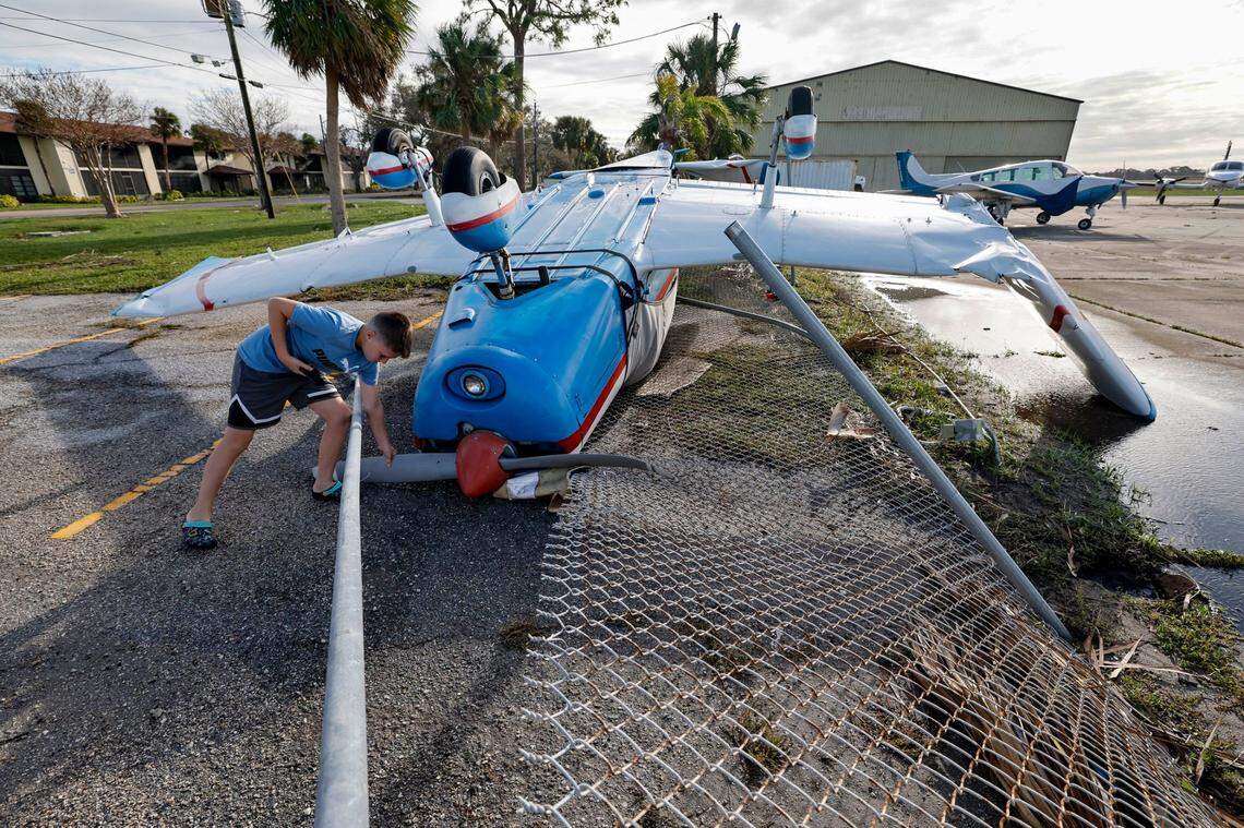 Yurii Chmyrid,11, inspects the propeller of an upside down plane damaged by Hurricane Milton at the Venice Municipal Airport on Thursday, Oct. 10, 2024.