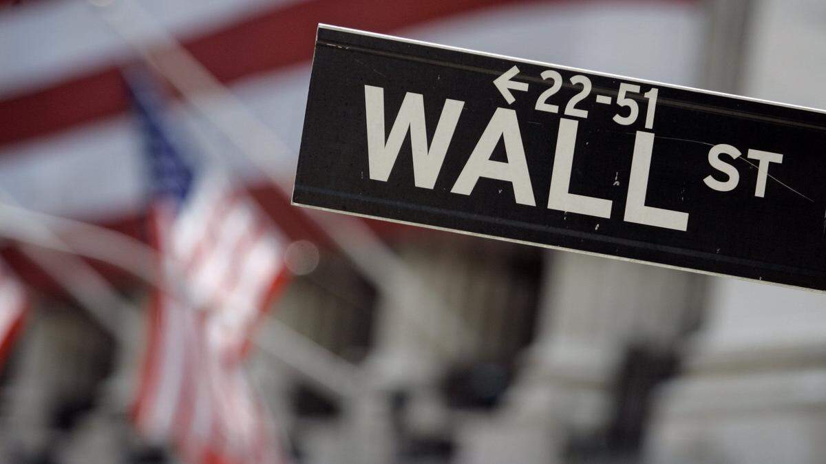 FILE - In this May 11, 2007, file photo, a Wall Street sign is mounted near the flag-draped facade of the New York Stock Exchange. Stocks are moving slightly lower in early trading Friday, Nov. 27, 2015, as traders return from the Thanksgiving holiday. Energy stocks fell more than the rest of the market as the price of oil turned lower. Disney lost ground after reporting declining subscriber numbers for ESPN. (AP Photo/Richard Drew, File)