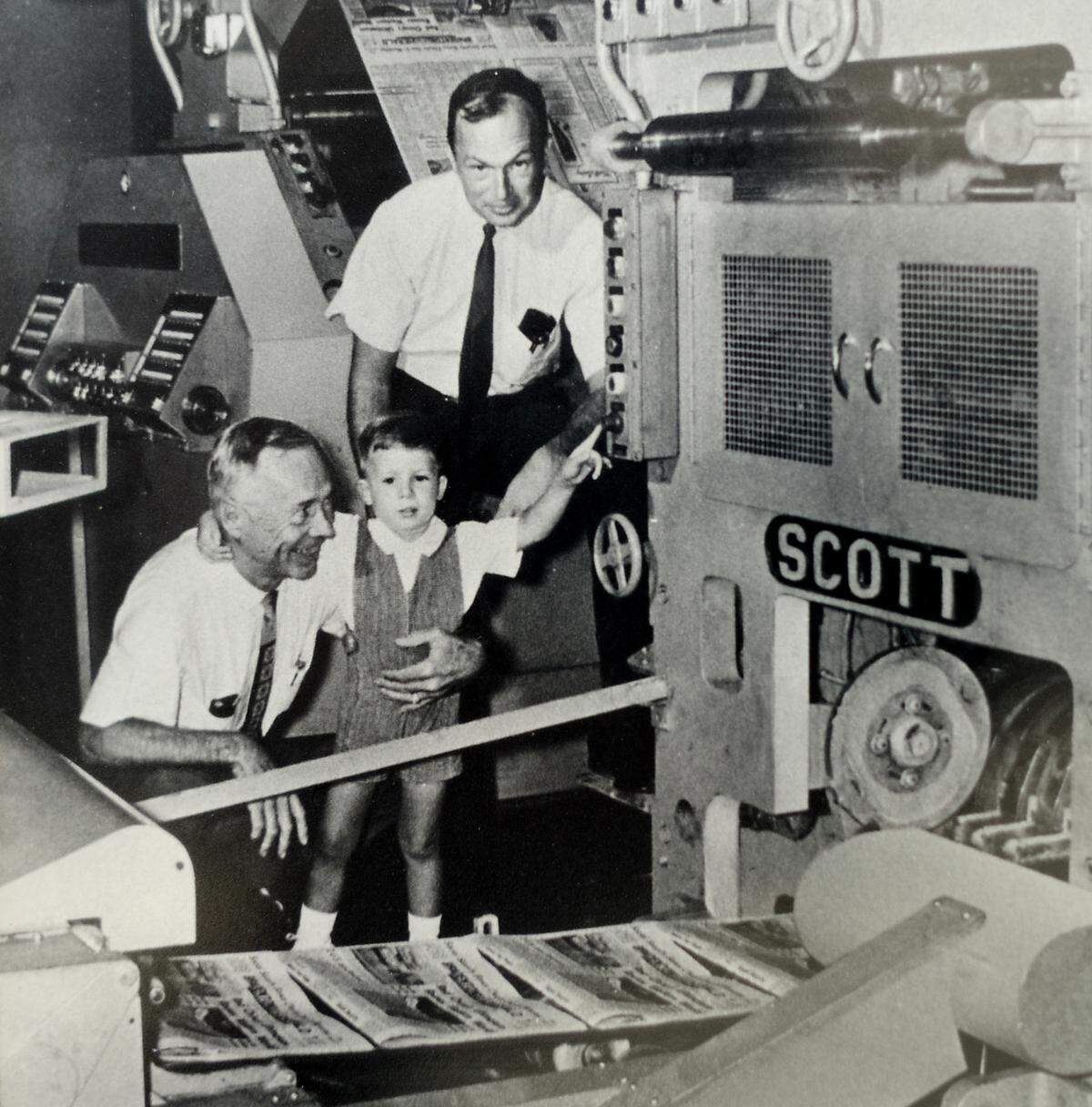 William Eugene “Gene” Page III, standing, is shown with his father, William Eugene Page Jr., and son, Gene IV in the newspaper pressroom.