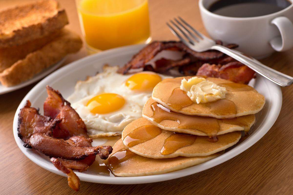 A delicious home style breakfast with crispy bacon, eggs, pancakes, toast, coffee and orange juice. (Dreamstime/ TNS)